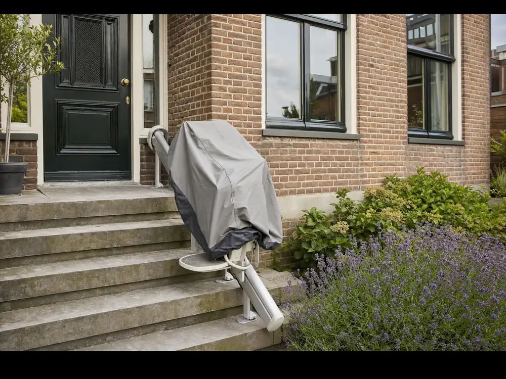Buitentraplift met beschermhoes bij de stoep van een Nederlandse woning